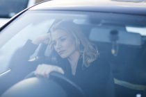 Погана бізнес-леді дивиться під час водіння в міському пробці — стокове фото