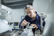 Female engineer turning valves on factory industrial piping — Stock Photo