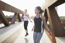 Two women training with skipping ropes on urban footbridge — Stock Photo