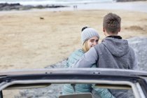 Coppia giovane con braccia intorno a vicenda in spiaggia, Constantine Bay, Cornovaglia, Regno Unito — Foto stock