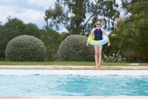 Chica joven de pie junto a la piscina - foto de stock