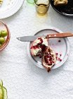 Stillleben mit geschnittenem Granatapfel auf Teller — Stockfoto