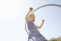 Visão de baixo ângulo da menina brincando com aro de plástico — Fotografia de Stock