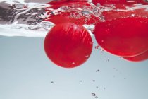 Globos de aire rojo bajo el agua - foto de stock