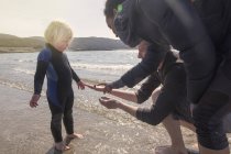 Niño y padres en la playa, Loch Eishort, Isla de Skye, Escocia - foto de stock