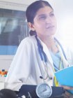 Medico donna che contempla note mediche in ospedale — Foto stock