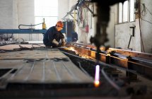 Trabalhador usando equipamentos em instalações de fabricação de guindastes, China — Fotografia de Stock
