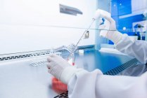 Laboratorio de investigación del cáncer, manos enguantadas de científicos preparando células para la centrifugadora - foto de stock