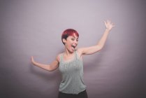 Studioporträt einer jungen Frau mit kurzen rosa Haaren, die tanzt — Stockfoto
