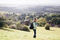 Menina em pé no campo olhando para a vista — Fotografia de Stock