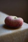 Peach on corner of cloth covered table — Stock Photo