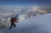 Альпинист движется вверх по глубокому снегу, Швейцарские Альпы, Кантон Уоллис, Швейцария — стоковое фото