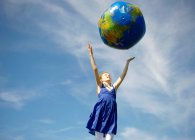Junges Mädchen wirft aufblasbare Weltkugel — Stockfoto