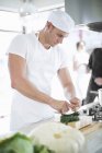 Male chef mixing using herb chopper in commercial kitchen — Stock Photo
