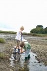 Dos chicos pescando con redes en un arroyo - foto de stock