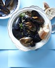 Bowl of tamarind mussels with bread slices — Stock Photo