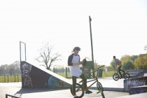 Dos jóvenes en bicicletas bmx en skatepark - foto de stock