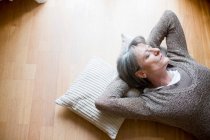 Old woman relaxing on floor — Stock Photo