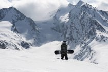 Young male snowboarder walking up mountain, Obergurgl, Austria — Stock Photo