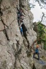 Four people rock climbing — Stock Photo