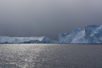 Бушующие облака и айсберги на Илулиссатском леднике — стоковое фото