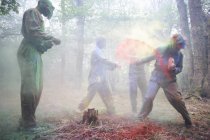 Paintball players in action with colorful paints in woods — Stock Photo