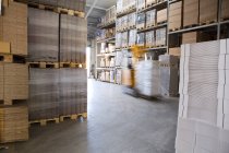 Blurred forklift truck in storage warehouse — Stock Photo