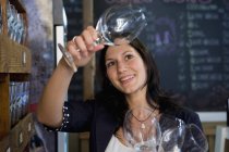 Frau kontrolliert Weingläser im Geschäft — Stockfoto