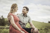 Happy young couple sitting on hillside, Cody, Wyoming, USA — Stock Photo