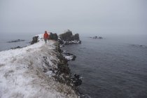Hombre parado en el borde del islote, Islandia - foto de stock