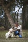 Young woman and dog in forest — Stock Photo