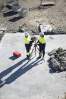 Vue en angle élevé du gestionnaire du site et de l'arpenteur sur le chantier — Photo de stock