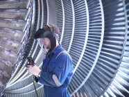 Ingenieur repariert Dampfturbinenschaufel mit Schleifer in Werkstatt — Stockfoto