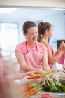 Teenager-Mädchen bereiten Karotten in der Küche zu — Stockfoto