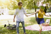 Young couple holding hands running — Stock Photo