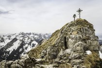 Joven excursionista masculino en el pico de la montaña Klammspitze, Oberammergau, Baviera, Alemania - foto de stock
