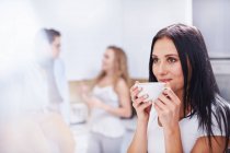 Mujer joven bebiendo café en la cocina - foto de stock