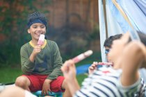 Ragazza e due fratelli mangiare lecca-lecca di ghiaccio in giardino — Foto stock