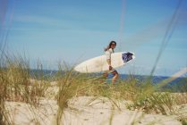 Femme avec planche de surf sur la plage, Lacanau, France — Photo de stock