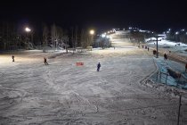 Esquiadores esquiando por la pista de esquí por la noche, Hemavan, Suecia - foto de stock