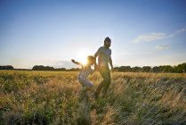 Father and son out walking in park field — Stock Photo