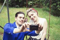 Молодая винтажная пара делает селфи в саду — стоковое фото