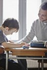 Father helping son with homework at home — Stock Photo