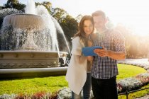 Ehepaar nutzt digitales Tablet im Park — Stockfoto