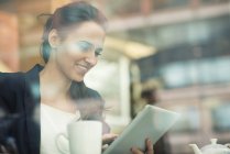 Junge Geschäftsfrau mit Touchscreen auf digitalem Tablet im cafe, london, uk — Stockfoto