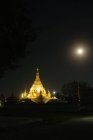 Templo y luna llena por la noche - foto de stock