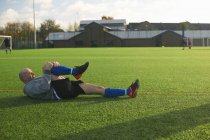 Fußballer dehnt sich vor Spiel auf dem Feld — Stockfoto