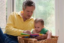 Abuelo leyendo nieto una historia - foto de stock