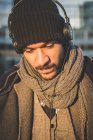 Retrato de hombre con estilo escuchando música con auriculares - foto de stock