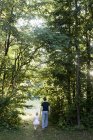 Отец и дочь идут через лес, вид сзади — стоковое фото